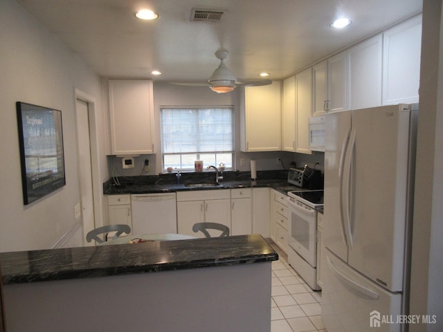 kitchen featuring white appliances, visible vents, white cabinets, and a sink