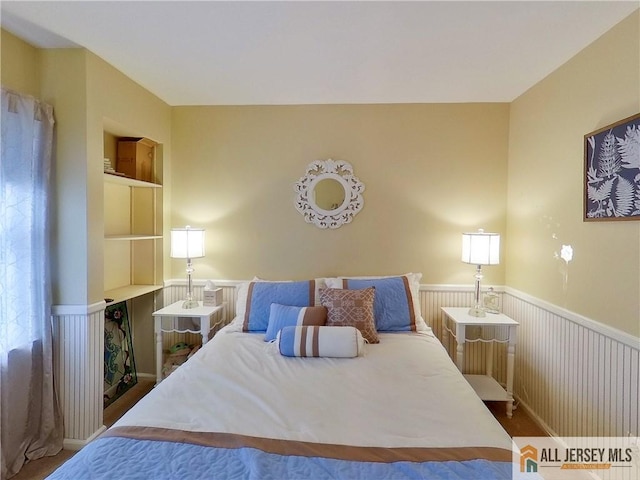 bedroom featuring wainscoting