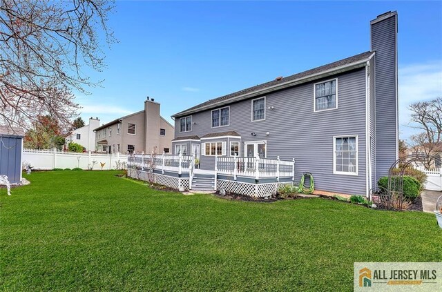 back of property with a chimney and a wooden deck