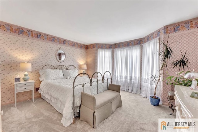 carpeted bedroom with wallpapered walls and baseboards