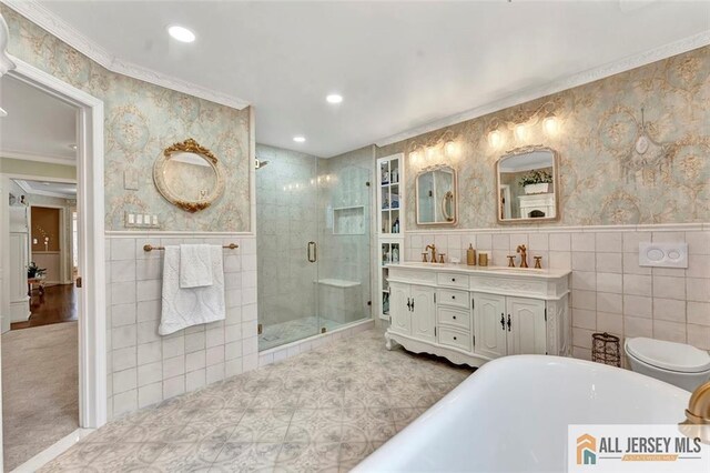 bathroom featuring tile walls, a shower stall, a freestanding bath, recessed lighting, and crown molding