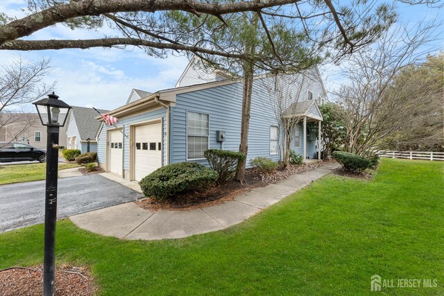 view of home's exterior featuring a garage and a yard