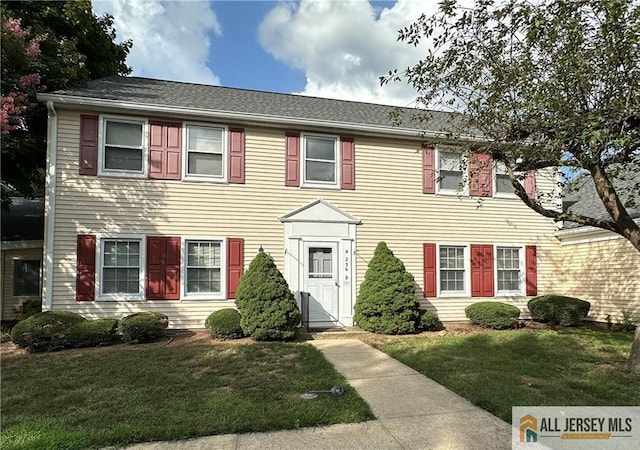 colonial inspired home featuring a front lawn