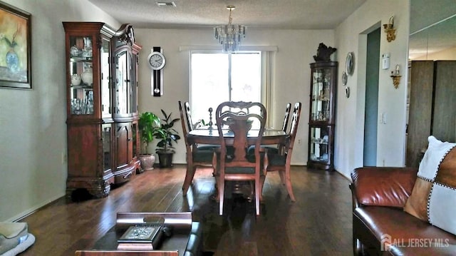 dining space featuring a chandelier, dark wood-style flooring, and visible vents