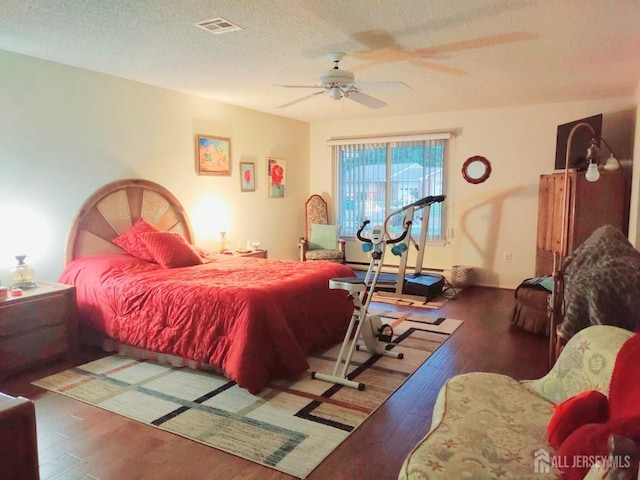 bedroom with a ceiling fan, a textured ceiling, and hardwood / wood-style floors