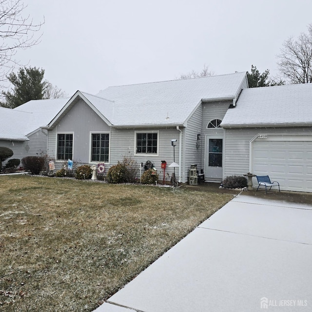 rear view of property featuring a lawn and a garage