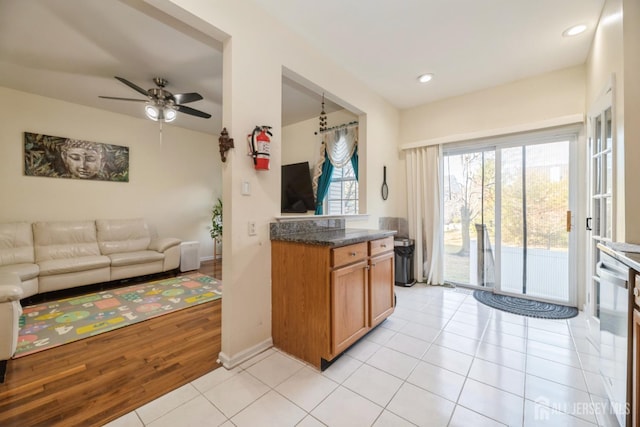 1404 Yarrow Cir S, Brunswick, NJ 08810 - kitchen featuring ceiling fan, open floor plan, brown cabinets, light tile patterned flooring, and dark countertops
