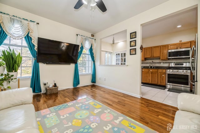 1404 Yarrow Cir S, Brunswick, NJ 08810 - living room featuring healthy amount of natural light, light wood finished floors, and ceiling fan