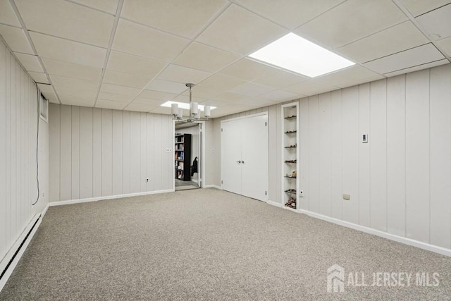 9 Valley Forge Dr, East Brunswick, NJ 08816 - below grade area with built in features, a baseboard heating unit, carpet floors, a paneled ceiling, and wood walls