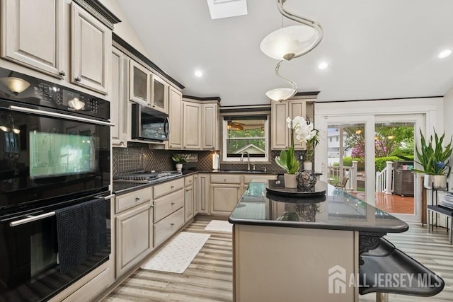 9 Valley Forge Dr, East Brunswick, NJ 08816 - kitchen featuring black appliances, dark countertops, decorative backsplash, light wood-style flooring, and a breakfast bar