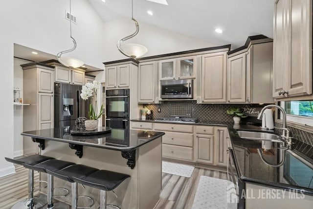 9 Valley Forge Dr, East Brunswick, NJ 08816 - kitchen with stainless steel appliances, light wood-style floors, decorative backsplash, a kitchen bar, and a center island