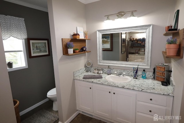 bathroom featuring vanity, toilet, baseboards, and ornamental molding