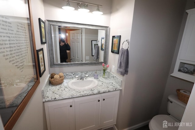 bathroom featuring toilet and vanity