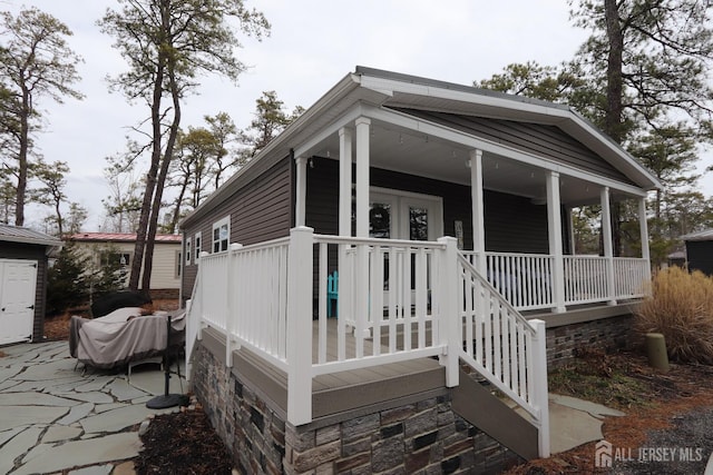 exterior space with stone siding and covered porch