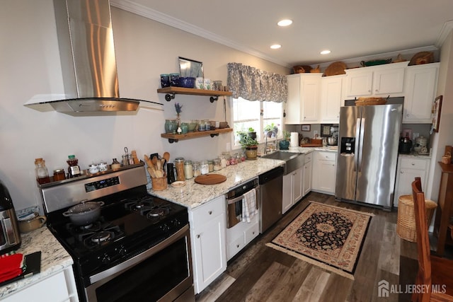 kitchen featuring a sink, appliances with stainless steel finishes, wall chimney exhaust hood, crown molding, and white cabinets