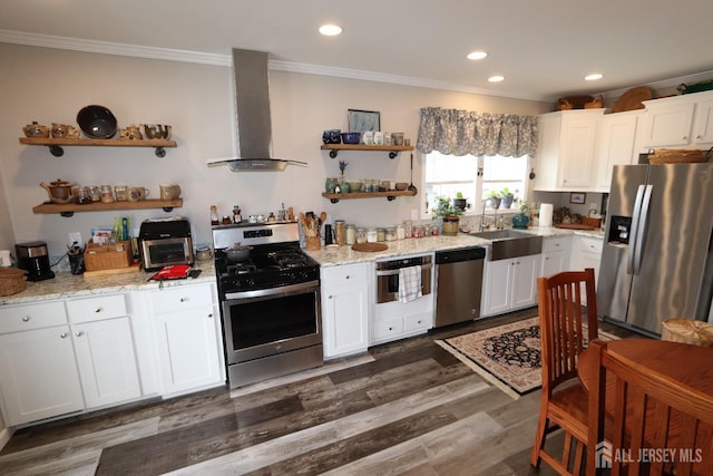 kitchen with ornamental molding, appliances with stainless steel finishes, wall chimney exhaust hood, and open shelves