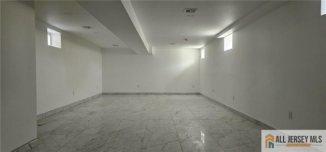 below grade area with marble finish flooring and baseboards