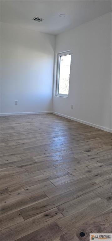 empty room with baseboards and wood finished floors