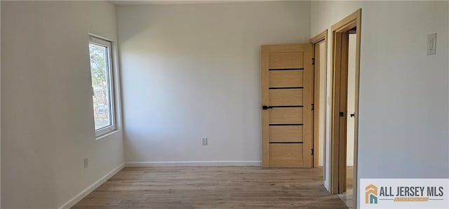unfurnished room featuring light wood-style flooring and baseboards