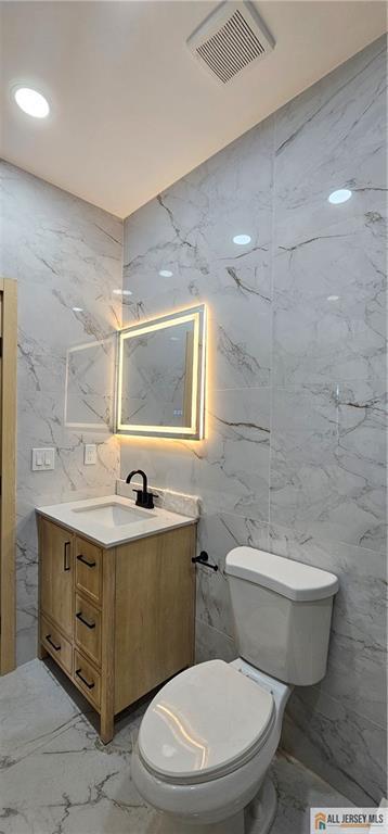 374 Oak St, Perth Amboy, NJ 08861 - half bath with marble tiled flooring, vanity, and tile walls