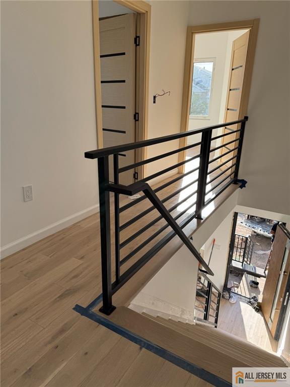 stairs with wood finished floors and baseboards