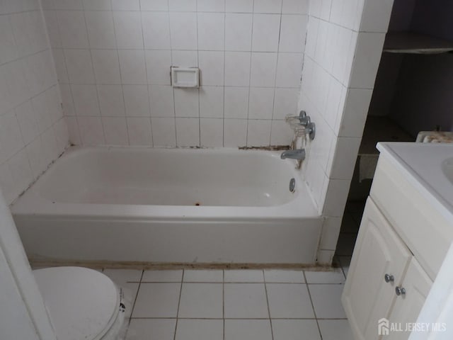 full bathroom featuring vanity, tile patterned flooring, a tub, and toilet