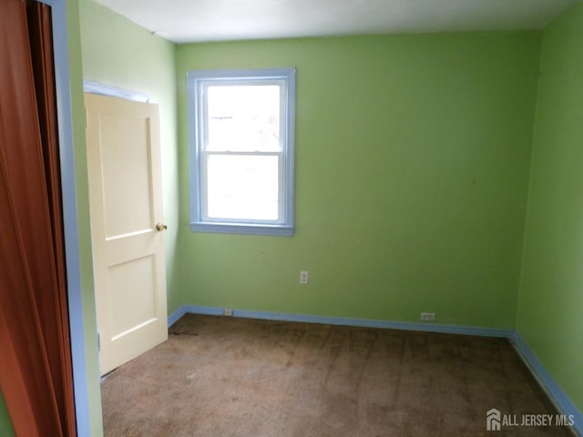 carpeted spare room with baseboards