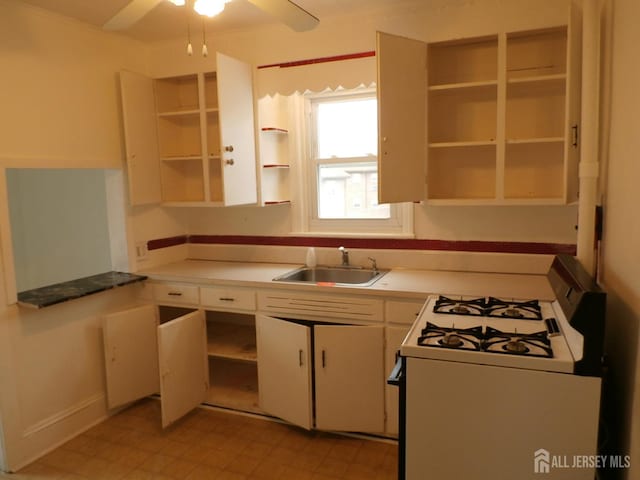 kitchen featuring open shelves, a sink, white gas range oven, and white cabinets