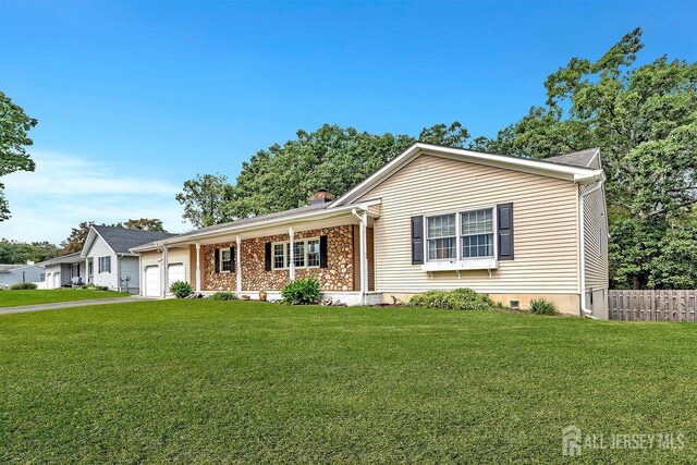 ranch-style home featuring a front lawn and a garage