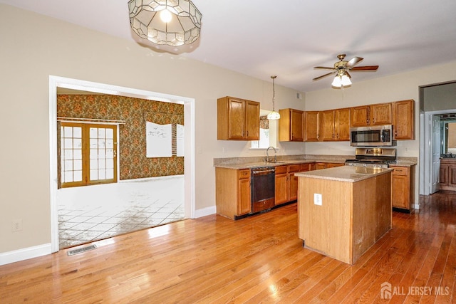 8 Staudt Ct, Franklin, NJ 08873 - kitchen with stainless steel appliances, wood finished floors, brown cabinetry, pendant lighting, and light countertops