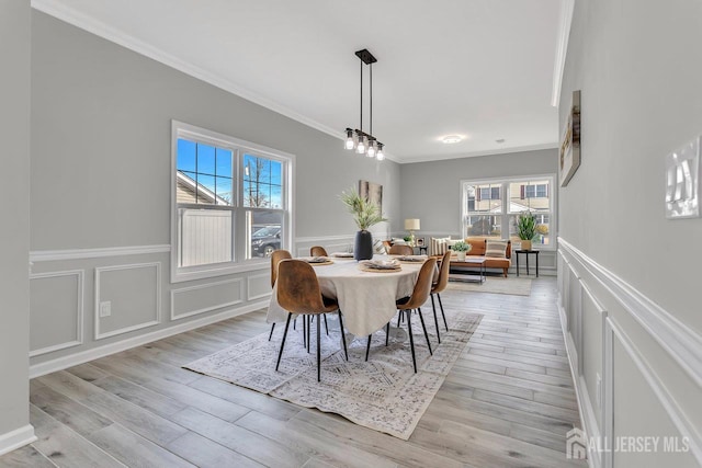 13 Markham Rd, Edison, NJ 08817 - dining space featuring ornamental molding, a decorative wall, plenty of natural light, wainscoting, and light wood-style flooring