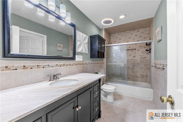19 Edgegrove St, Edison, NJ 08837 - bathroom featuring tile walls, vanity, tile patterned floors, combined bath / shower with glass door, and wainscoting