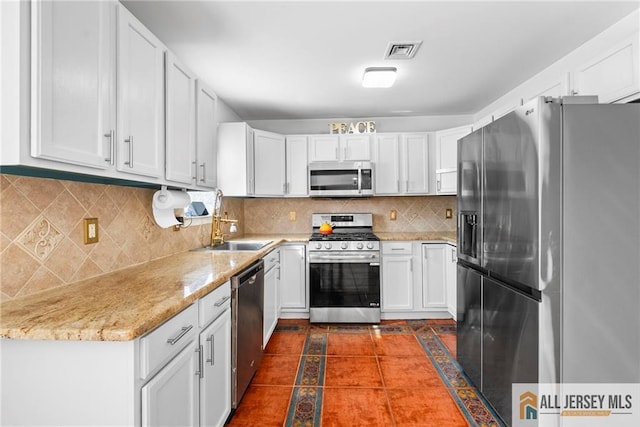 19 Edgegrove St, Edison, NJ 08837 - kitchen with appliances with stainless steel finishes, backsplash, white cabinetry, and light stone countertops