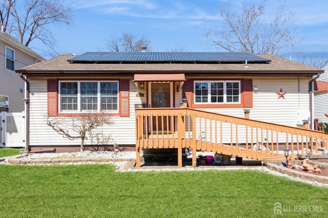 157 Orange St, Edison, NJ 08817 - back of property featuring a lawn, roof mounted solar panels, roof with shingles, and a deck