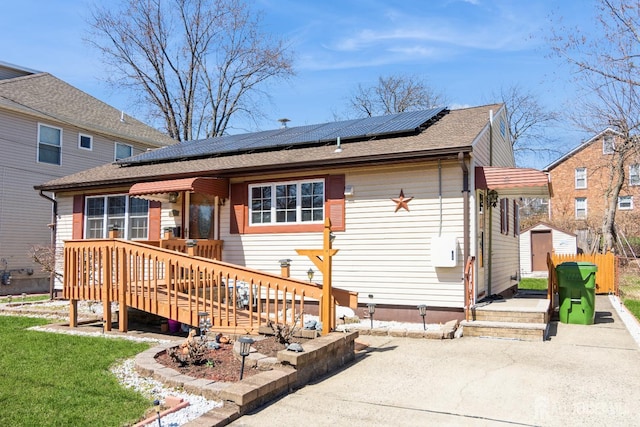 157 Orange St, Edison, NJ 08817 - rear view of house featuring solar panels, a wooden deck, and roof with shingles