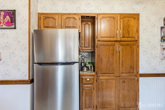 157 Orange St, Edison, NJ 08817 - kitchen with freestanding refrigerator, wallpapered walls, brown cabinets, and a wainscoted wall