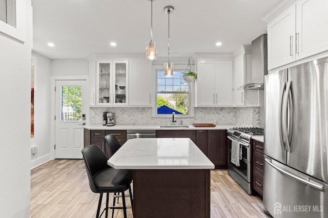 307 S 4th Ave, Highland Park, NJ 08904 - kitchen featuring appliances with stainless steel finishes, wall chimney range hood, a sink, white cabinetry, and recessed lighting