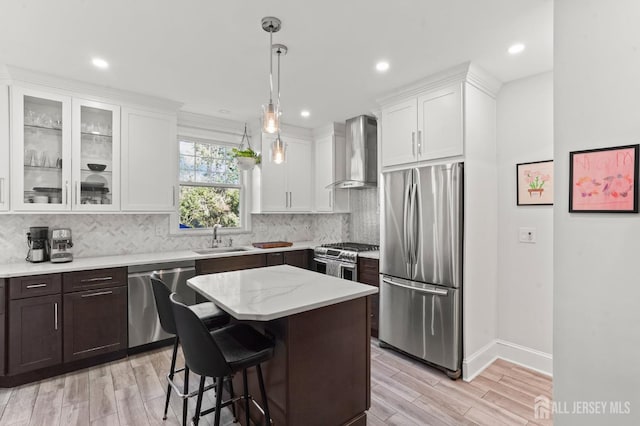 307 S 4th Ave, Highland Park, NJ 08904 - kitchen featuring appliances with stainless steel finishes, wall chimney exhaust hood, a sink, light wood-style flooring, and recessed lighting