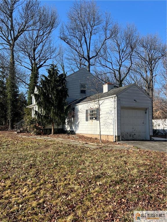 view of side of property with a garage and a yard