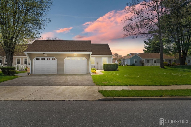 view of front of home featuring a garage, a lawn, and driveway