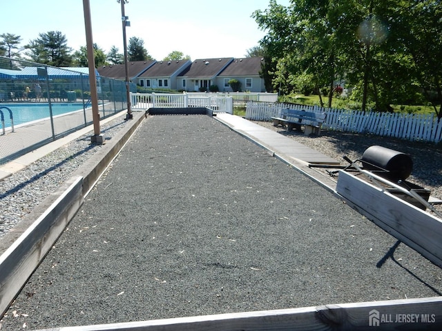 view of community with fence, a residential view, and a pool