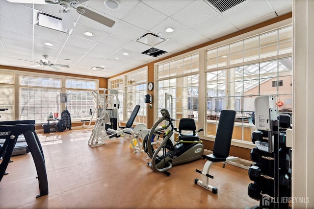 exercise room featuring visible vents, a paneled ceiling, and a ceiling fan