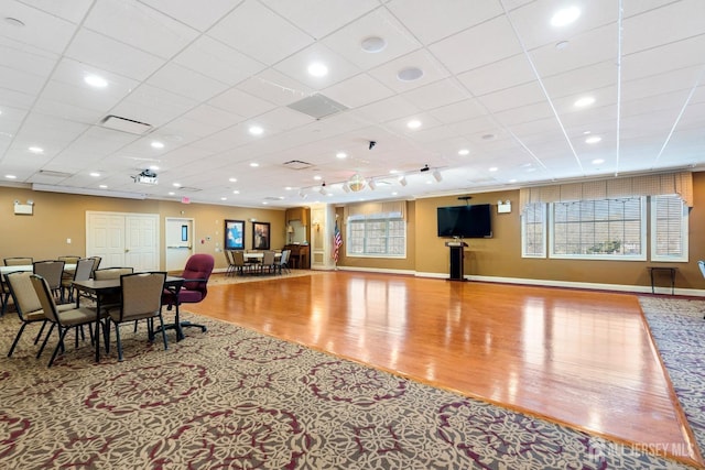 interior space with visible vents, wood finished floors, a paneled ceiling, and baseboards