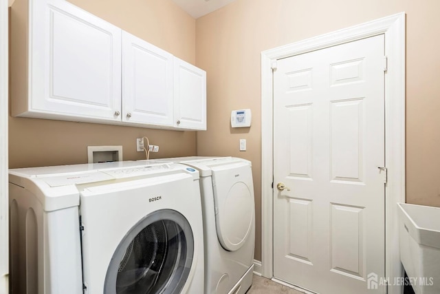 clothes washing area with cabinet space and washing machine and clothes dryer