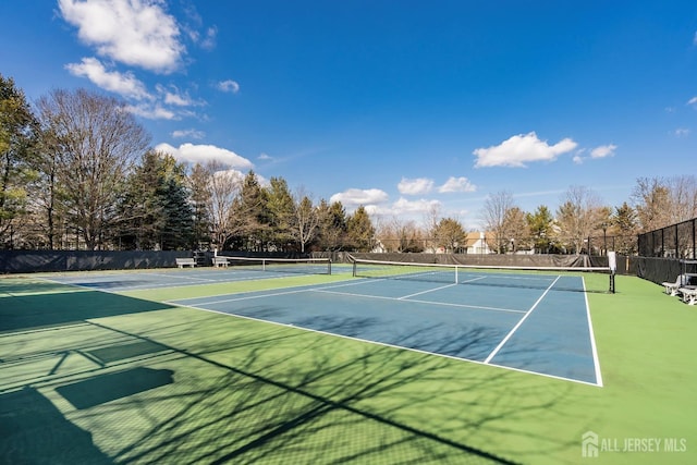 view of tennis court featuring fence