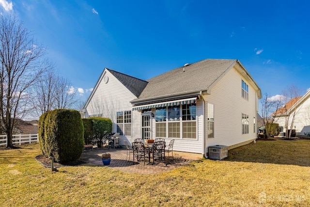 rear view of property featuring a patio area, a shingled roof, fence, and a lawn