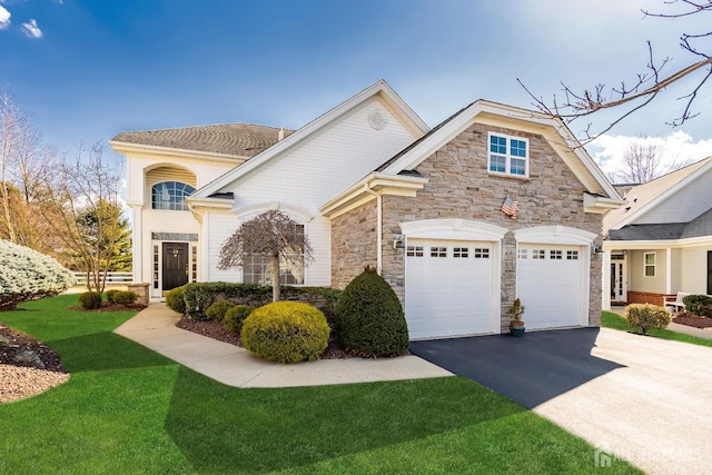 view of front facade with aphalt driveway, a front yard, stone siding, and a garage