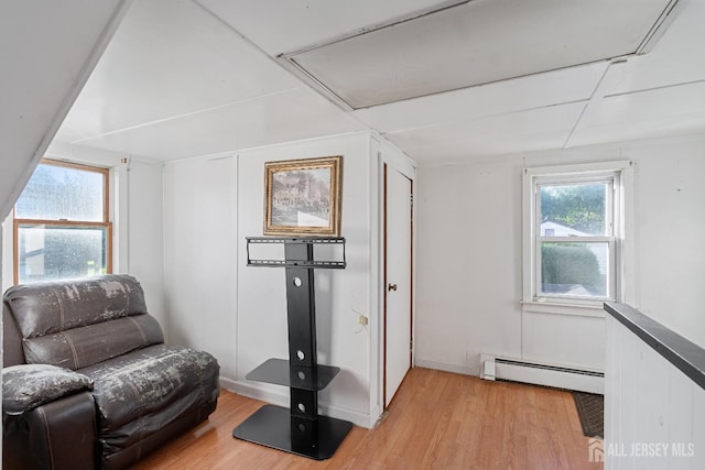 living area with a baseboard radiator and light hardwood / wood-style flooring