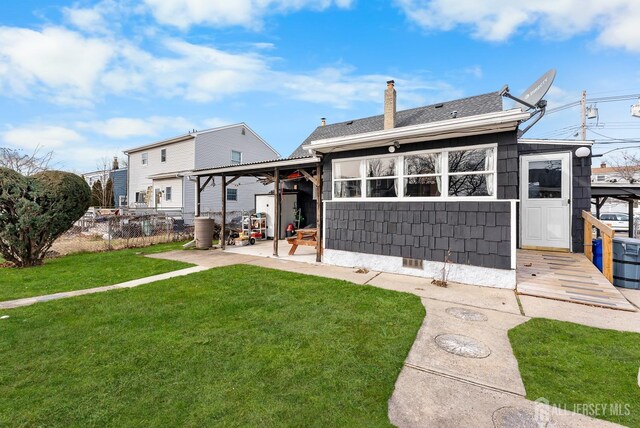 rear view of house with a lawn and a patio