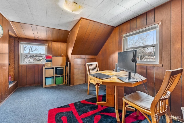 office area featuring vaulted ceiling, carpet, and wood walls